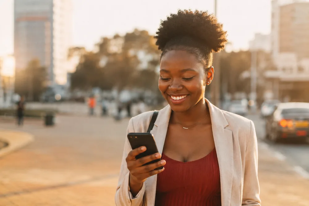A ZimMula customer checking her phone in the city
